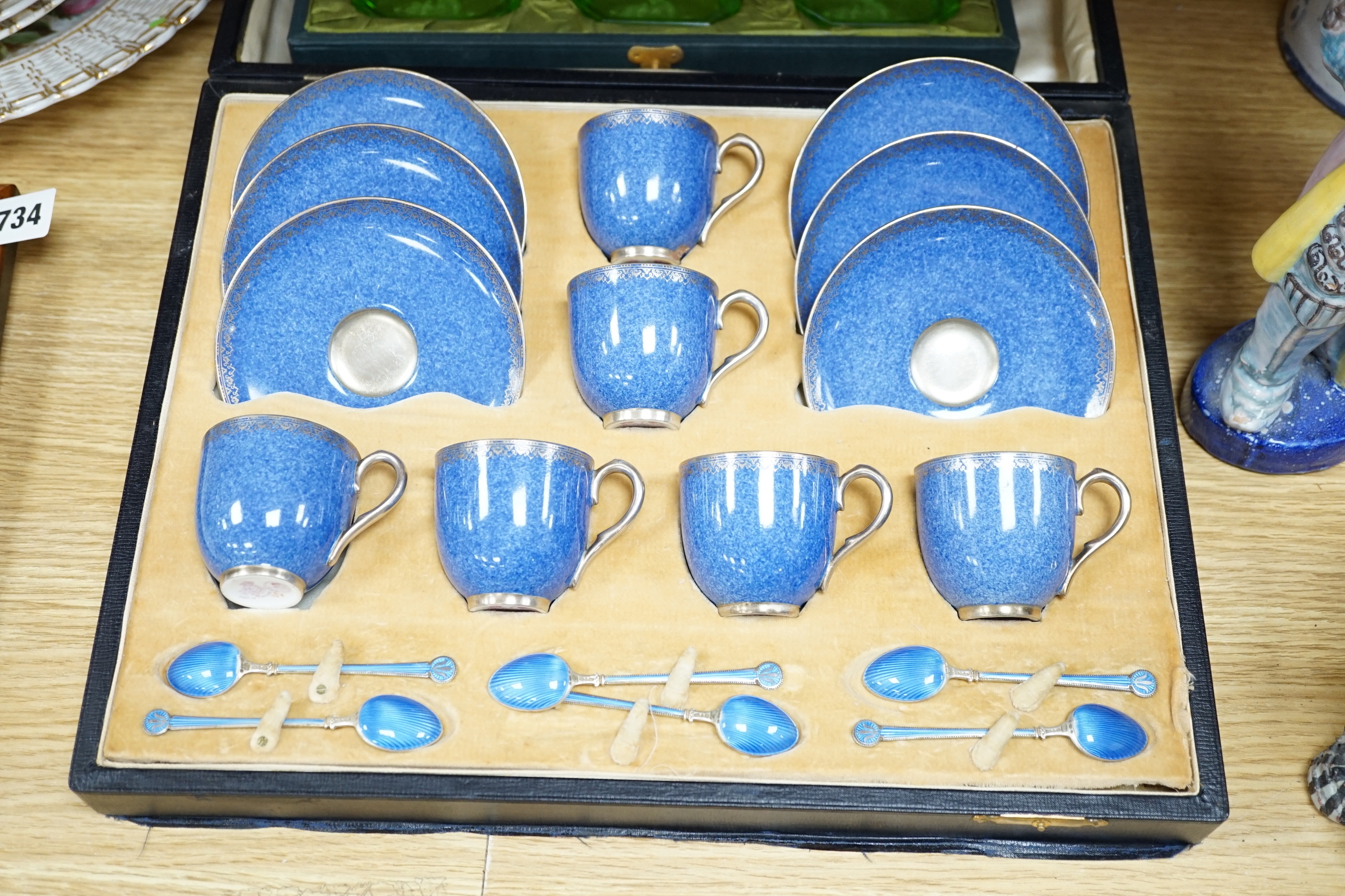 A cased Worcester powder blue and silvered coffee set with enamelled silver spoons together with a cased set of six green and frosted glass salts